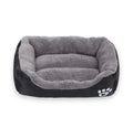 Grey plush dog bed with black exterior and a white paw print